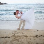 groom dips bride on the beach in st thomas